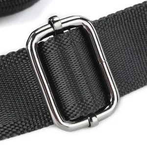 Detailed shot of durable black nylon bag strap with shiny metal adjuster buckle.
