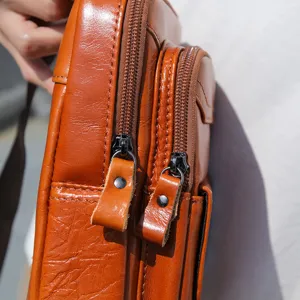 Primer plano detalle de bolso de pecho de cuero encerado vintage para hombre, calidad.