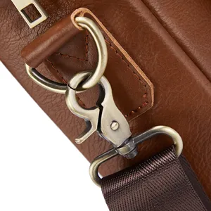 Close-up detail of genuine leather men bag metal hardware strap connector antique brass.