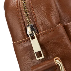 Close-up detail of men's genuine leather bag showing fine zipper hardware and premium cowhide texture.