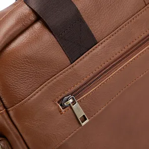 Close-up detail of a brown genuine leather business briefcase zipper and strap design.