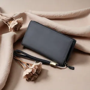 Detail view of dark grey men's leather long wallet with zipper and wrist strap.
