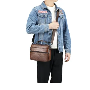 Brown leather men's messenger bag detail, showing multi-pocket design and texture.