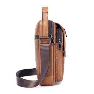 Side detail view of brown leather men crossbody bag, showing multi-zipper compartments.