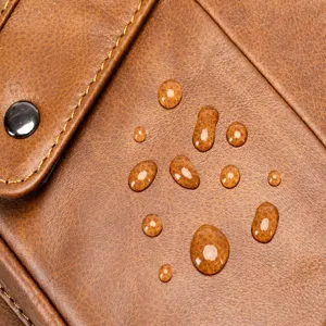 Close up view of premium brown cowhide leather men bag showing waterproof water drop details.