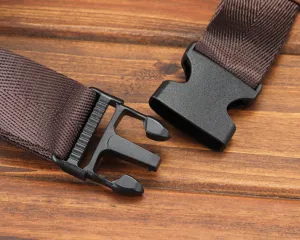 Gros plan d'une sangle en nylon marron durable avec boucle de dégagement en plastique noir.