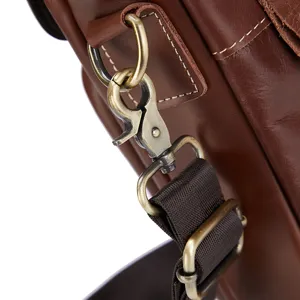 Detail of men's genuine leather messenger bag with vintage metal hardware and durable strap.