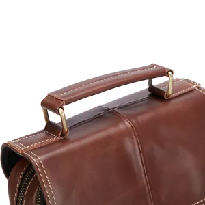 Close-up detail of genuine leather men's bag handle with fine stitching and hardware.