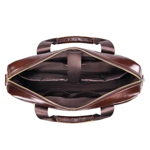 Top view detail of brown leather briefcase interior showing storage compartments and metal zippers.
