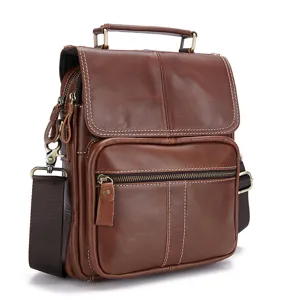 Detail shot of brown leather men's messenger bag showing texture, zippers, and sturdy handle.