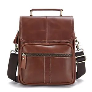 Close-up of brown genuine leather men messenger bag featuring fine stitching and metal hardware.