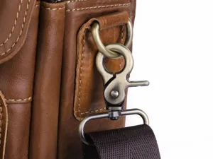 Close-up detail of genuine leather men messenger bag with vintage bronze hardware and stitching.