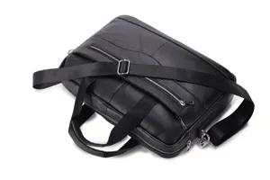 Detailed view of the premium black genuine leather men's business briefcase with shoulder strap.