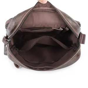 Leather shoulder bag interior detail showing multiple compartments and secure zipper pockets clearly.