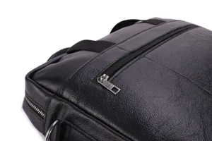 Detail shot of black leather men's briefcase zipper and fine texture craftsmanship.