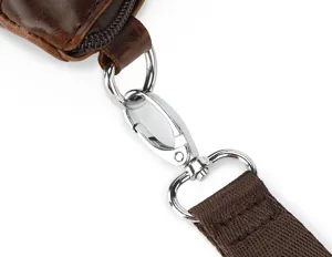 Close-up detail of the metal hardware swivel hook and brown leather strap for men leather bag.