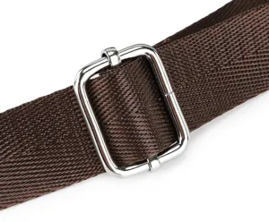 Detailed shot of durable brown bag strap with silver metal adjustable buckle and fine texture.