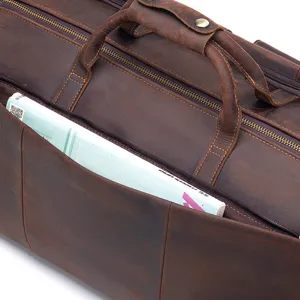 Genuine leather travel duffel bag detail, vintage brown luggage bag with sturdy handles.
