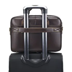 Detail view of dark brown leather business briefcase mounted on luggage handle for travel.