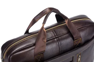 Detailed shot of the brown leather business laptop briefcase handles and textured surface.