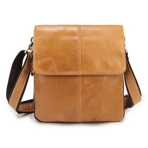 Brown leather detail closeup of vertical men crossbody shoulder bag with sturdy dark strap.
