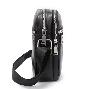 Side detail view of multi-compartment black leather men's shoulder bag with silver zippers.