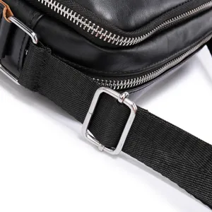 Close-up detail of black leather men messenger shoulder bag zipper and metal hardware.