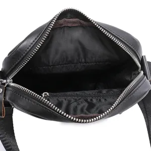Detailed top view of the black leather messenger bag interior, showing compartments and zippers.