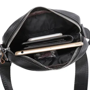 Detail view of black leather messenger bag interior showing spacious capacity with tablet and wallet.