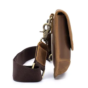 Detail shot of retro men's leather shoulder bag side profile and metallic hardware hooks.