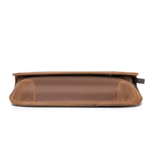 Close-up detail of brown leather bag side and bottom showing fine craftsmanship and texture.