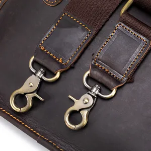 Close-up detail of vintage brown leather bag strap with durable metal hardware hook.