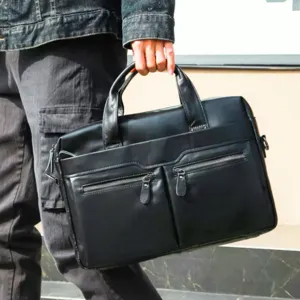 Detailed view of black leather business briefcase with dual zipper pockets and sturdy handle.