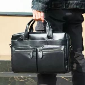 Detailed view of black leather business briefcase for men, featuring dual handles and pockets.