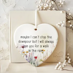 Ceramic heart hanging ornament detail showcasing warm friendship quote and delicate wild flowers.