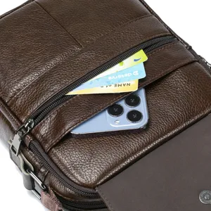 Close up of brown leather men messenger bag pocket detail with card and phone storage.