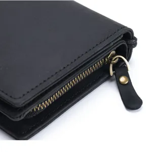 Close-up of black crazy horse leather men's wallet showing zipper and pull tab detail.