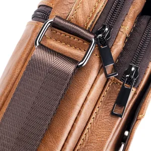 Detailed shot of men's leather shoulder bag showing metal hardware and zipper design.