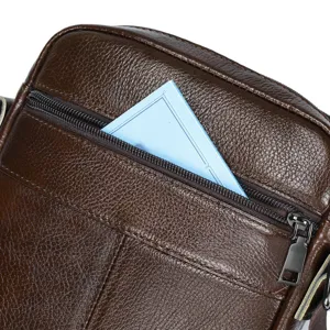 Close-up detail of mens brown leather crossbody bag zipper pocket texture durable design