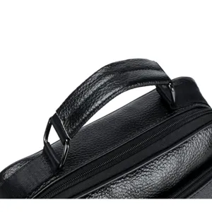 Detailed close-up of genuine leather men bag handle, black texture and metal hardware.