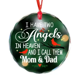 Detailed view of round crystal glass Christmas memorial ornament with red cardinal bird design.