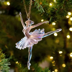Gros plan d'un ornement de ballerine transparent et scintillant sur un sapin de Noël.