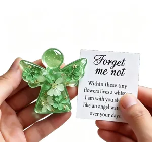 Close-up detail of green resin angel keepsake ornament with embedded dried flowers.