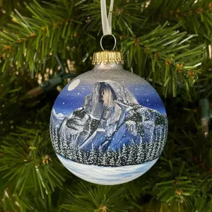 Hand-painted Christmas bulb ornament featuring detailed winter mountain landscape and snow.