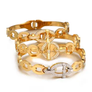 Gros plan sur le bracelet élégant à maillons dorés avec fermoir OT et zircon scintillant.