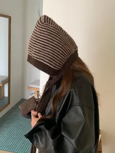 Brown striped knitted balaclava hat detail shot, showing cozy winter ear protection design.