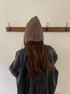 Detail shot of a cozy brown striped knitted balaclava hood, showing soft texture and back view.