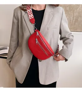 Vue détaillée d'un sac de poitrine rouge en cuir doté d'une large sangle élégante.