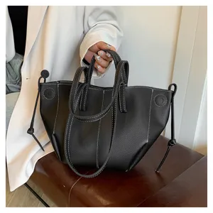 Classic black leather tote bag with white contrast stitching and stylish winged design.