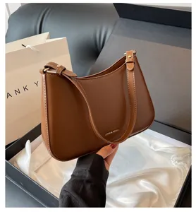 Brown leather baguette shoulder bag for women, chic underarm purse with metal logo detail.